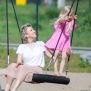Single Swing (BNS 90cm) üzerinde sallanan çocuk ve yetişkin, oyun alanı ekipmanı.