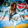 Powerclimber climbing net üzerinde tırmanan çocuk ile mavi ipten yapılmış oyun alanı ekipmanı.